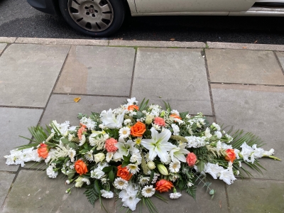 Orange and white casket spray