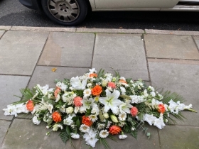 Orange and white casket spray