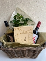 Wine, chocolates and plant in basket